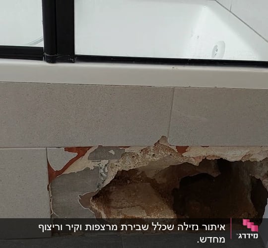 חור בקיר אריחים ליד אמבטיה